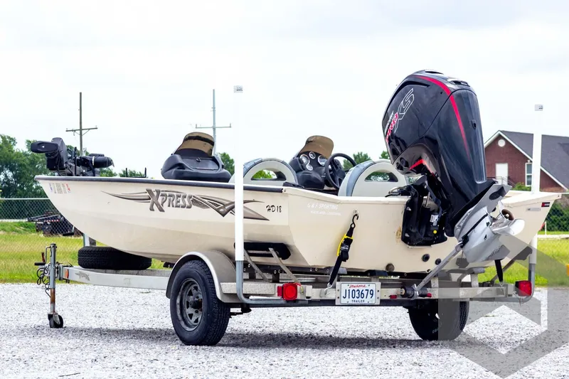 Slide: The Image of 2008 Xpress HD18SCA boat on trailer with outboard motor, parked on gravel. - 6