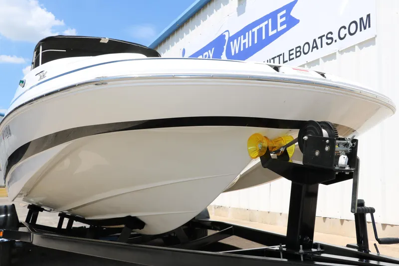 Slide: The Image of 2000 Chris-Craft 232 boat on trailer, displayed outside dealership. - 13