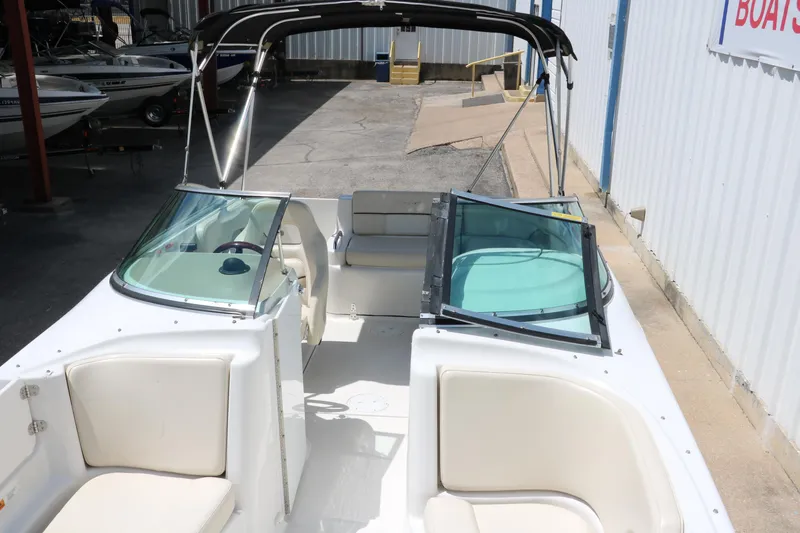 Slide: The Image of Interior view of 2000 Chris-Craft 232 boat with white seating and open windshield. - 23