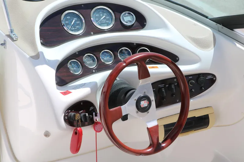 Slide: The Image of Steering wheel and dashboard of 2000 Chris-Craft 232 boat with gauges and controls. - 30