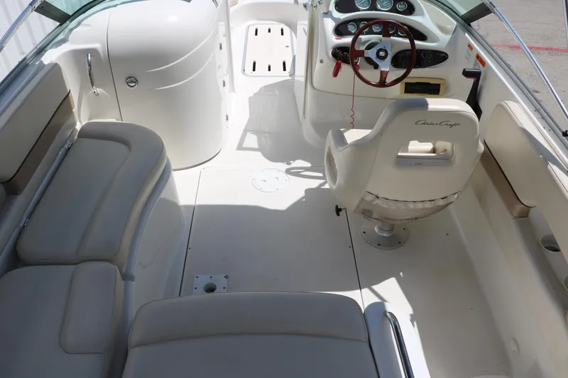 Slide: The Image of Interior of 2000 Chris-Craft 232 boat with white seating and steering console. - 35