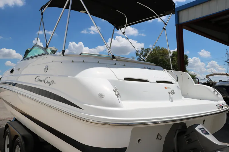 Slide: The Image of 2000 Chris-Craft 232 boat with canopy, docked under blue sky. - 7