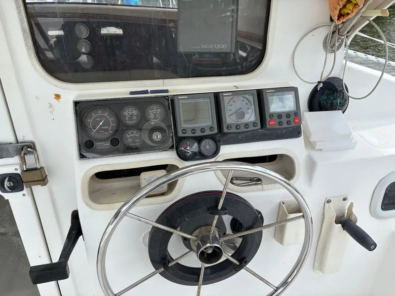 Slide: The Image of Steering wheel and control panel of a 1999 Gemini 105M boat. - 22