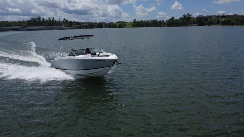 Slide: The Image of 2023 Cobalt R6 boat cruising on a lake under a partly cloudy sky. - 13