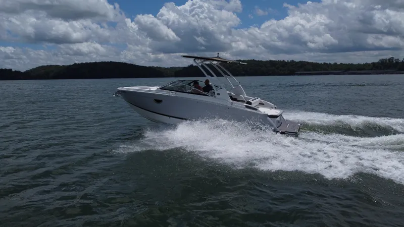 Slide: The Image of 2023 Cobalt R6 boat cruising on a lake under a partly cloudy sky. - 2