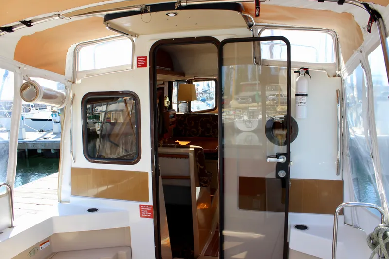 Slide: The Image of 2011 Ranger Tugs R-27 boat interior with glass door and seating area. - 13