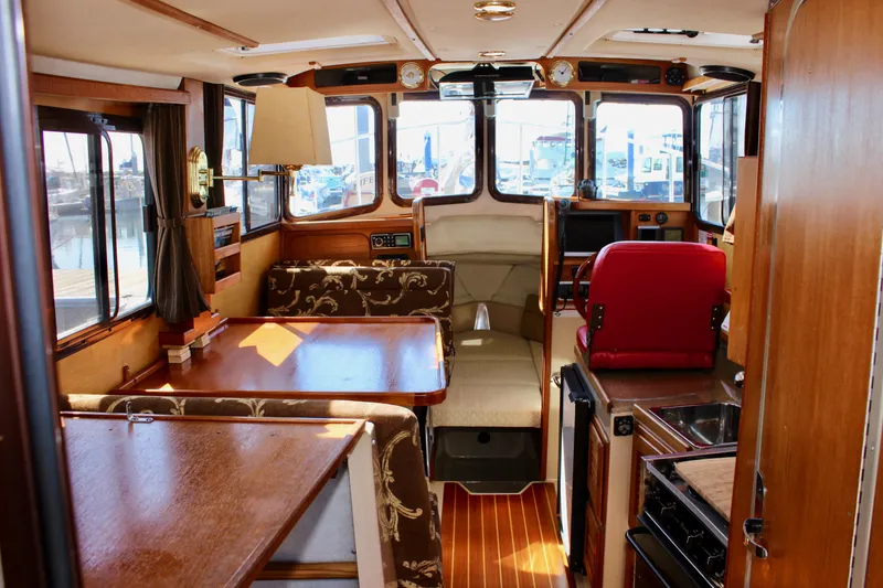 Slide: The Image of Interior of a 2011 Ranger Tugs R-27 boat with wood finishes and seating area. - 17