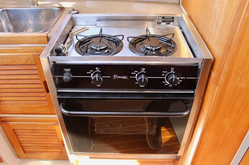 Slide: The Image of Stove and oven in 2011 Ranger Tugs R-27 boat kitchen, featuring dual burners. - 24