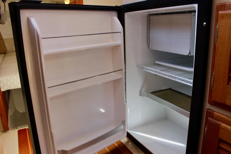 Slide: The Image of Open refrigerator inside 2011 Ranger Tugs R-27 boat, showing shelves and freezer compartment. - 26