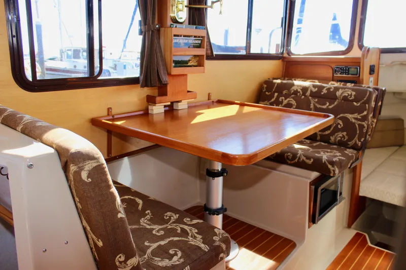 Slide: The Image of Interior of 2011 Ranger Tugs R-27 with wood table and patterned seating. - 28