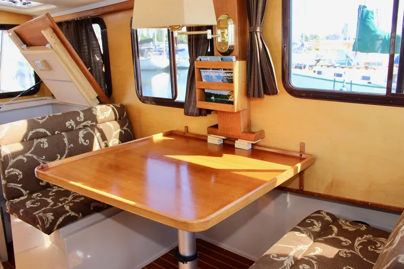 Slide: The Image of Interior of 2011 Ranger Tugs R-27 with wooden table and patterned seating. - 29