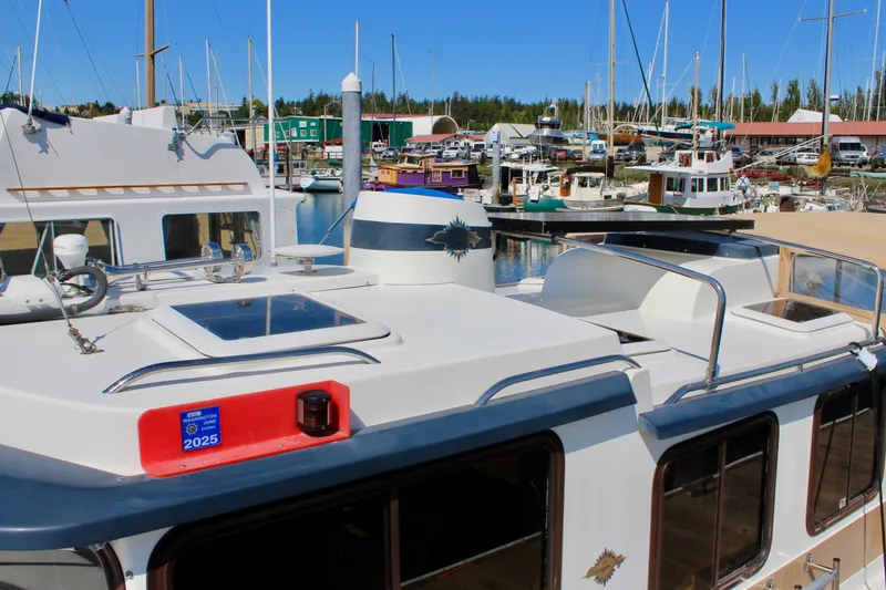 Slide: The Image of 2011 Ranger Tugs R-27 boat docked in a marina with other vessels in the background. - 3