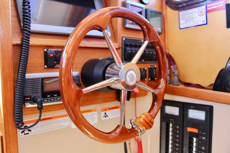 Slide: The Image of Steering wheel of 2011 Ranger Tugs R-27 boat, featuring wooden and metal design. - 32