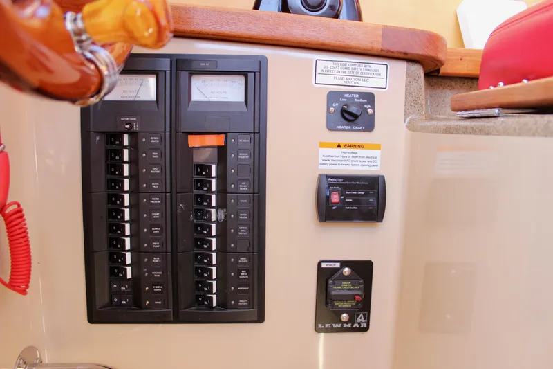 Slide: The Image of Electrical panel of a 2011 Ranger Tugs R-27 boat, featuring circuit breakers and controls. - 38