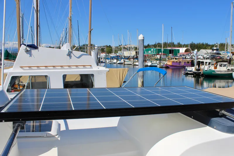 Slide: The Image of 2011 Ranger Tugs R-27 with solar panel, docked in a marina under clear blue skies. - 4