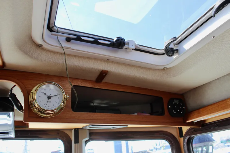 Slide: The Image of Interior view of 2011 Ranger Tugs R-27 boat, featuring a skylight and mounted clock. - 41