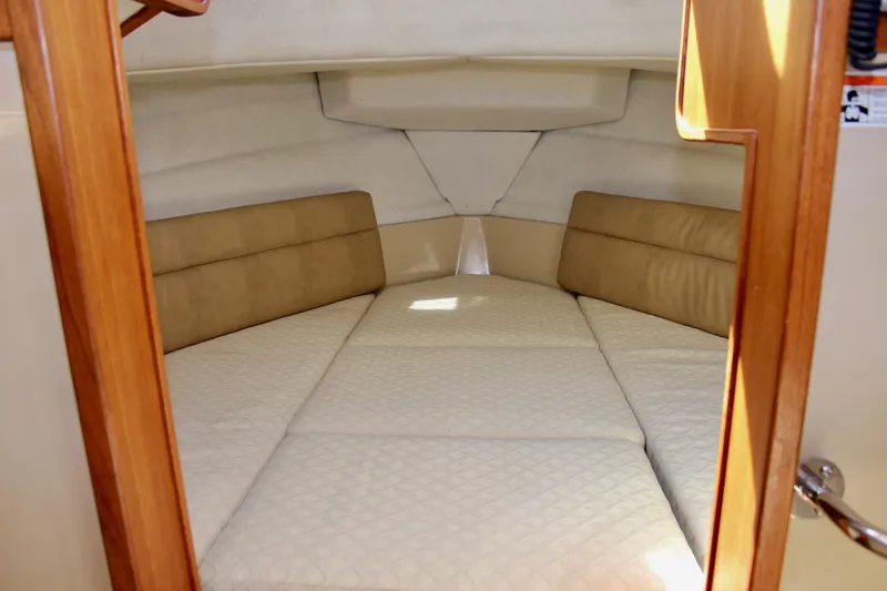 Slide: The Image of 2011 Ranger Tugs R-27 cabin interior with beige cushions and wooden accents. - 44