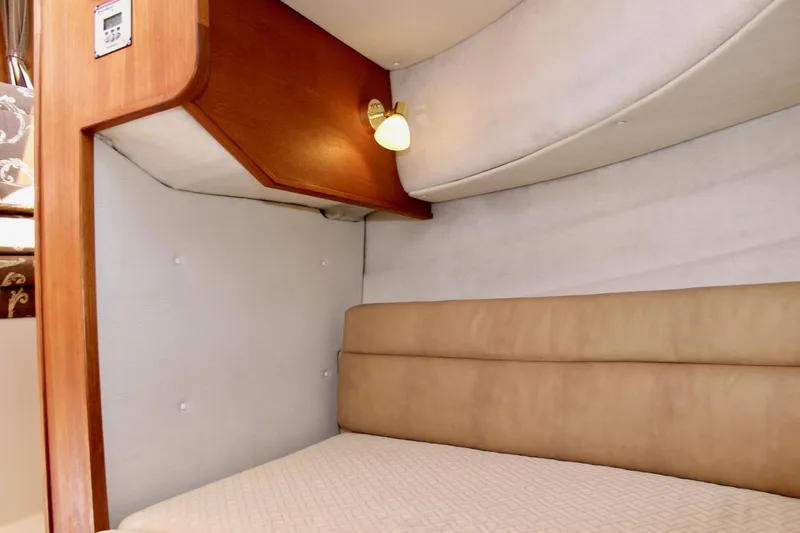 Slide: The Image of 2011 Ranger Tugs R-27 interior cabin with beige seating and wooden accents. - 45