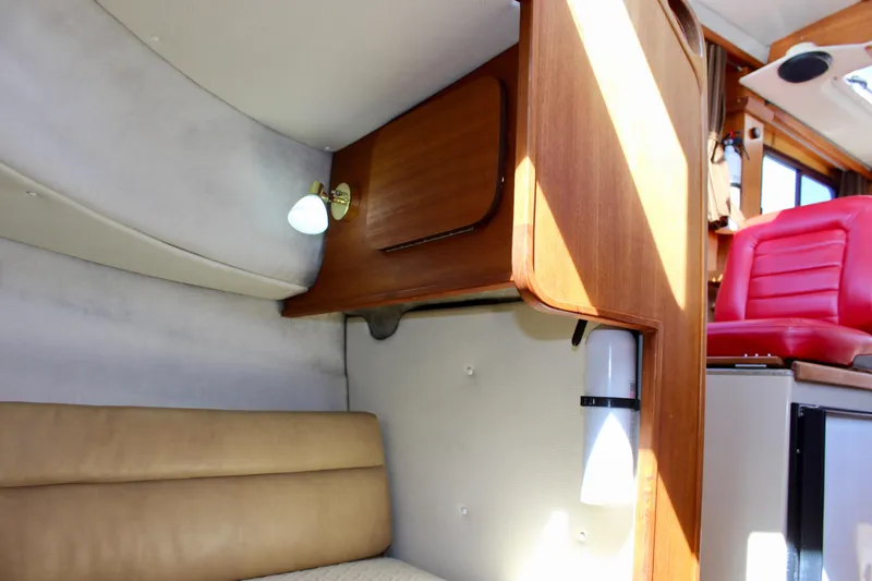 Slide: The Image of 2011 Ranger Tugs R-27 interior with wood cabinetry and beige seating. - 46