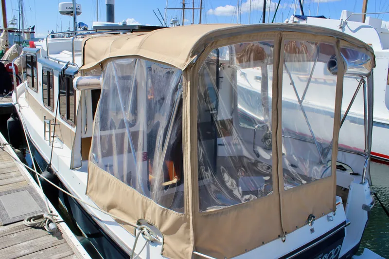 Slide: The Image of 2011 Ranger Tugs R-27 boat with tan canopy docked at marina. - 6