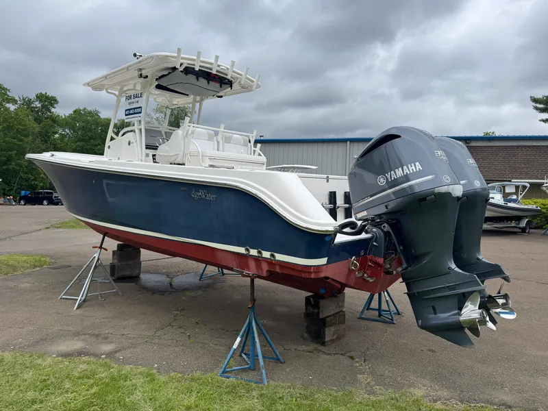 Slide: The Image of 2013 Edgewater 318CC boat with Yamaha engines on stands, displayed outdoors. - 4