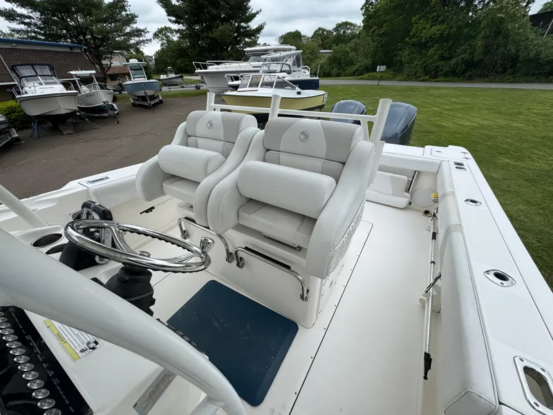 Slide: The Image of 2013 Edgewater 318CC boat interior with dual white seats and steering wheel. - 5
