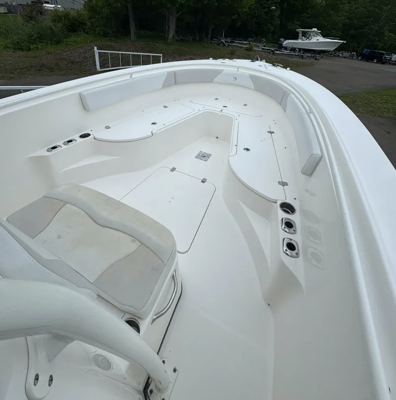 Slide: The Image of 2013 Edgewater 318CC boat interior with white seating and spacious deck. - 7