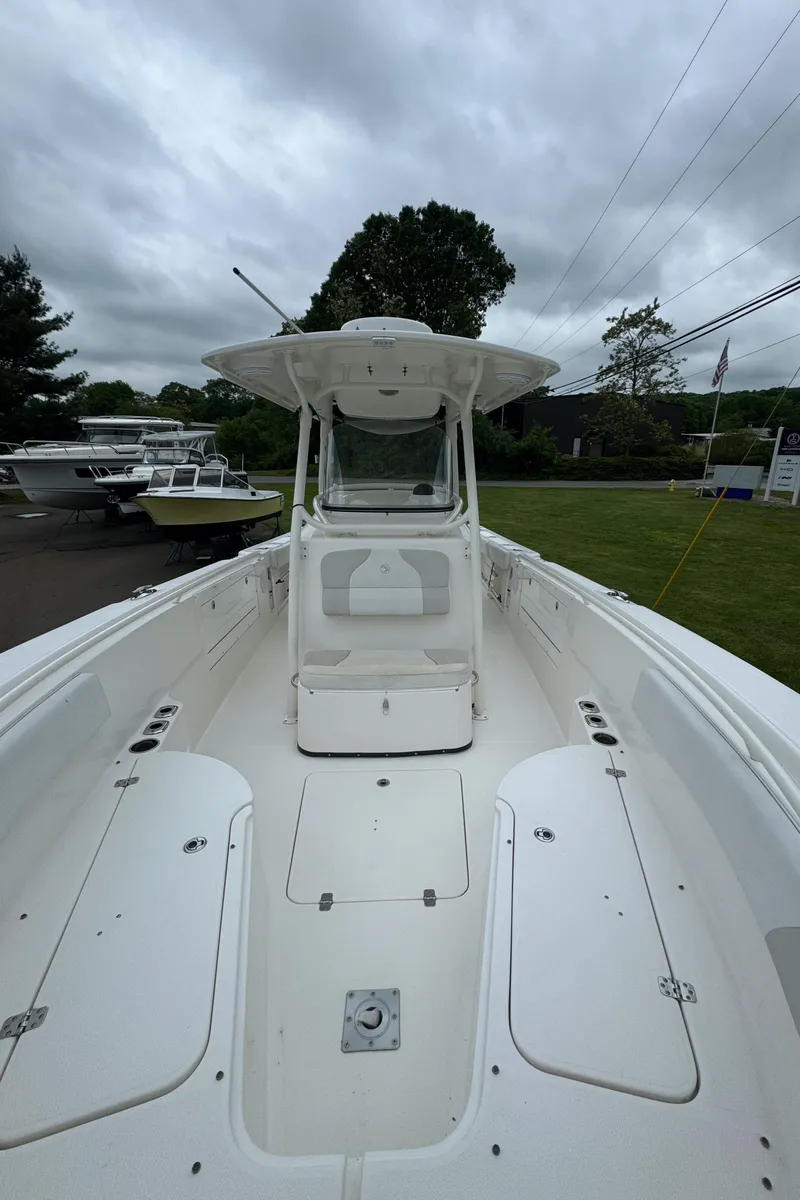 Slide: The Image of 2013 Edgewater 318CC boat with spacious deck and seating, under cloudy sky. - 8