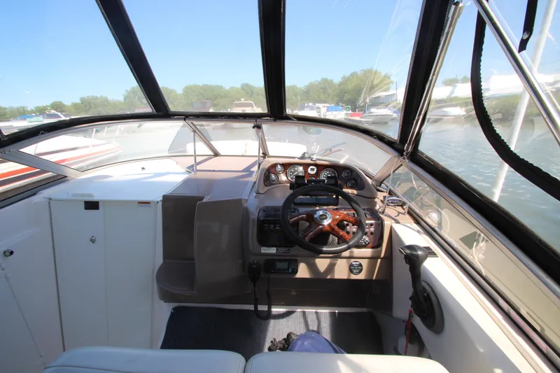 Slide: The Image of 2004 Regal 2665 Commodore boat cockpit with steering wheel and dashboard controls. - 10