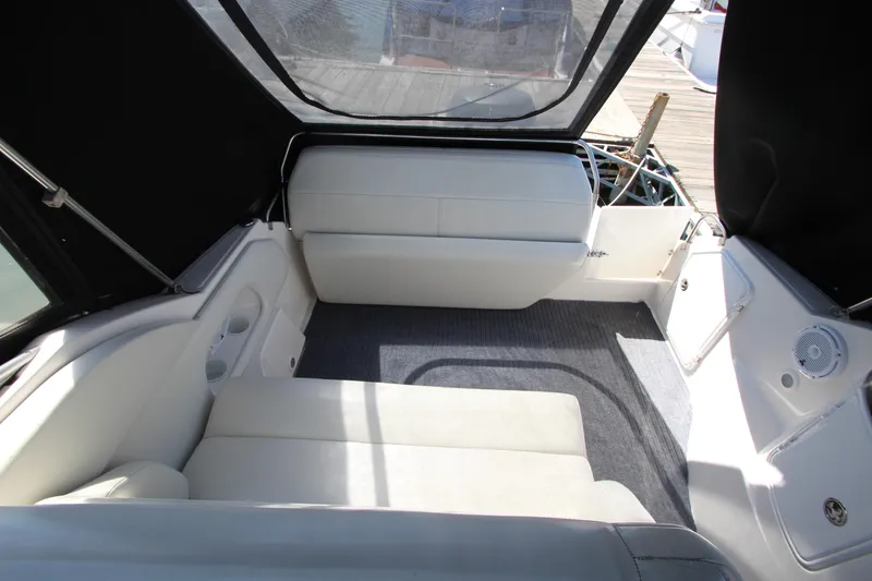 Slide: The Image of 2004 Regal 2665 Commodore boat interior with white seating and carpeted floor. - 12