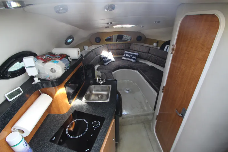 Slide: The Image of 2004 Regal 2665 Commodore cabin interior with kitchenette and seating area. - 13