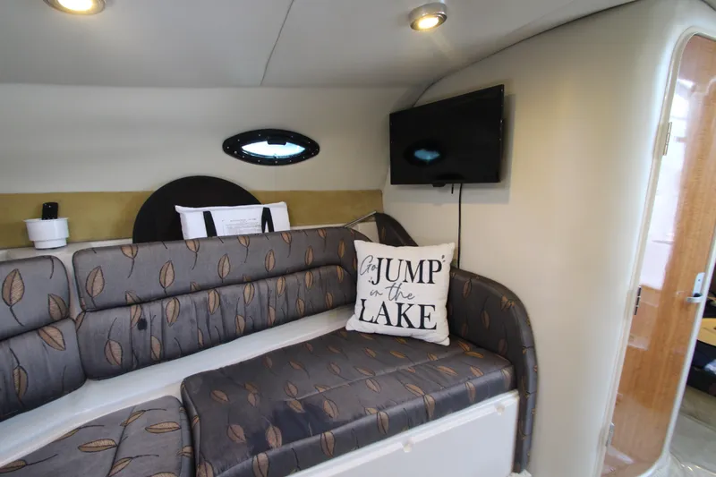 Slide: The Image of 2004 Regal 2665 Commodore cabin with cozy seating, TV, and decorative pillow. - 19