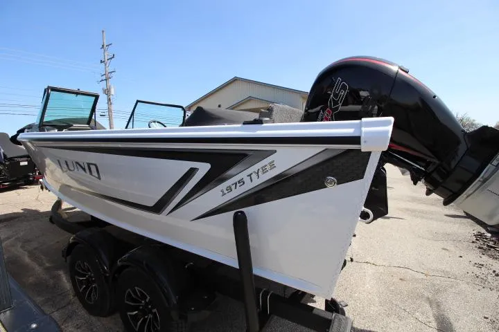 Slide: The Image of 2025 Lund 1975 Tyee boat with outboard motor, parked on a trailer. - 1
