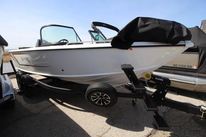 Slide: The Image of 2025 Lund 1975 Tyee boat on trailer, parked outdoors, side view. - 2