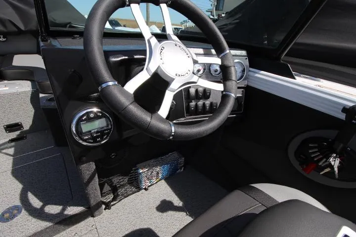Slide: The Image of Interior view of 2025 Lund 1975 Tyee boat, featuring steering wheel and dashboard controls. - 5