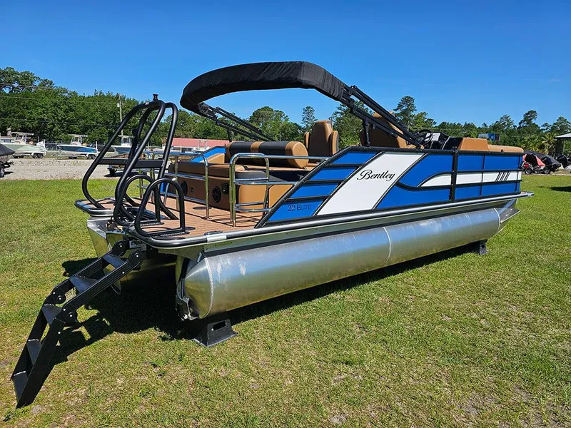 Slide: The Image of 2025 Bentley Pontoons 223 Elite Swingback Tritoon on grass, featuring dual captain seats. - 3