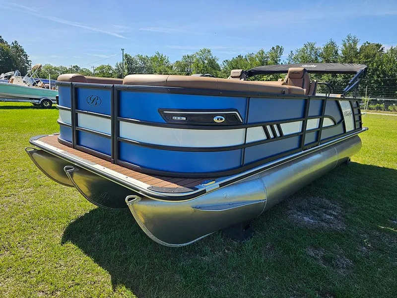 Slide: The Image of 2025 Bentley Pontoons 223 Elite Swingback Dual Captain Full Tritoon on grass, showcasing sleek design. - 5