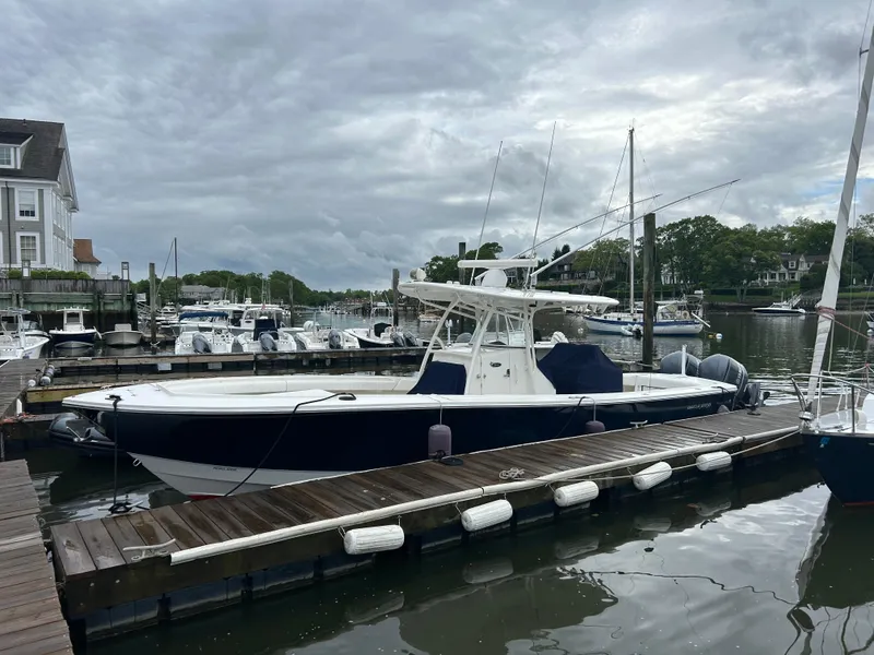 The Image of 2014 Regulator 34 boat docked at a marina under cloudy skies. - 0
