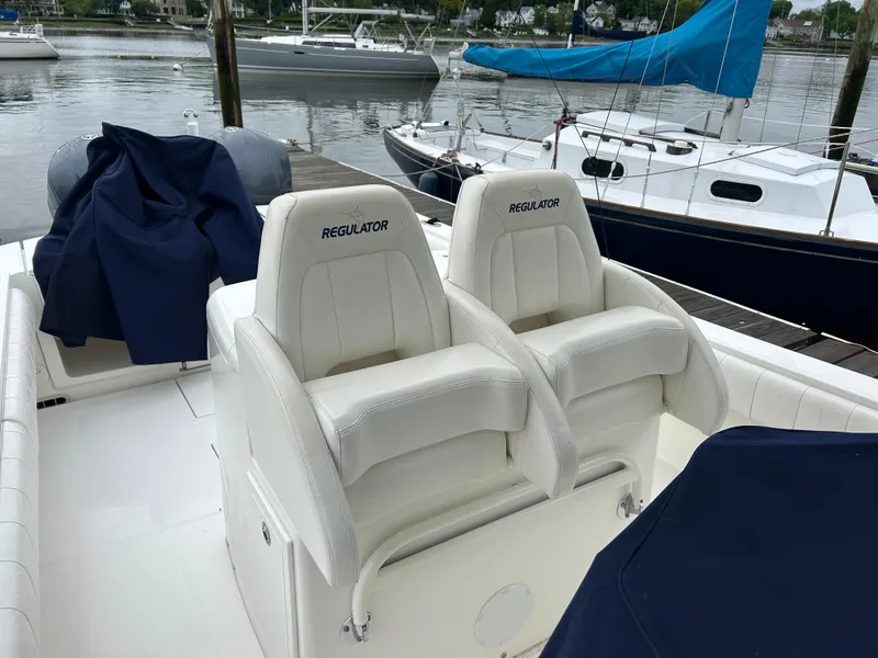Slide: The Image of 2014 Regulator 34 boat with white seating, docked near other sailboats. - 11