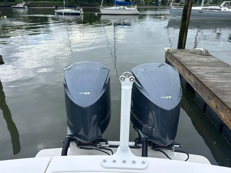 Slide: The Image of Twin outboard motors on a 2014 Regulator 34 boat docked by the water. - 19