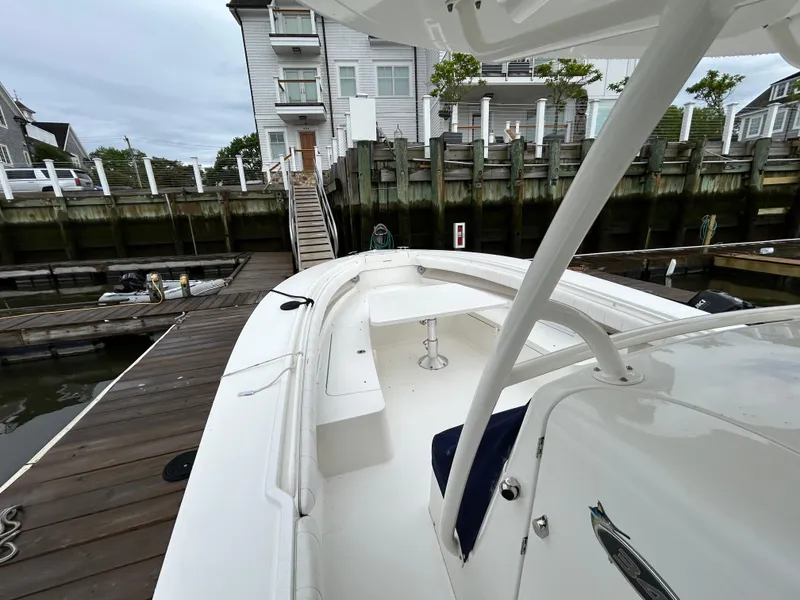 Slide: The Image of 2014 Regulator 34 boat docked at a marina, showcasing spacious deck and seating area. - 24
