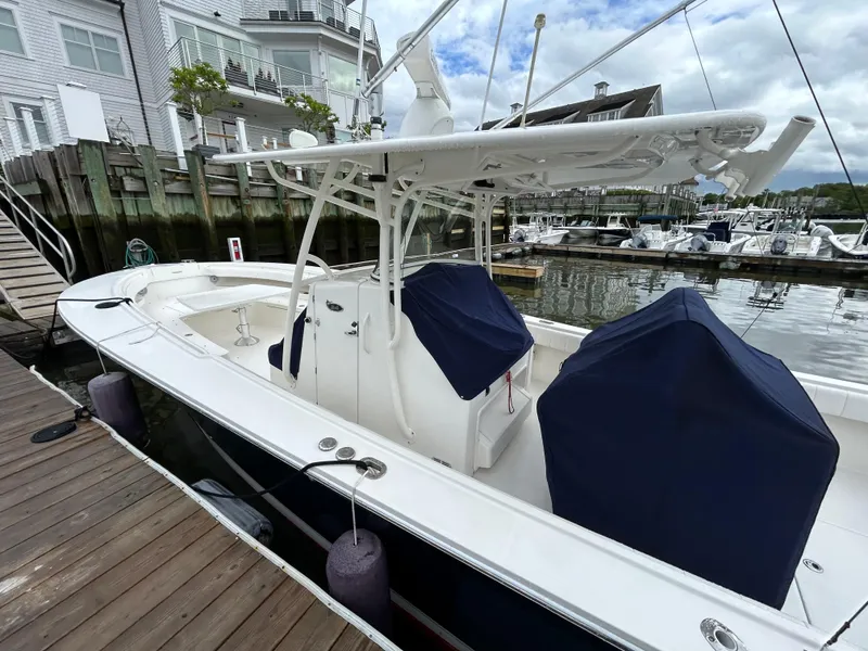 Slide: The Image of 2014 Regulator 34 boat docked at a marina, featuring covered seating and a T-top. - 26