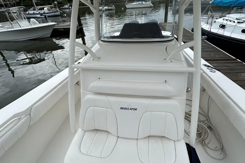 Slide: The Image of 2014 Regulator 34 boat interior with white seating at a marina. - 33