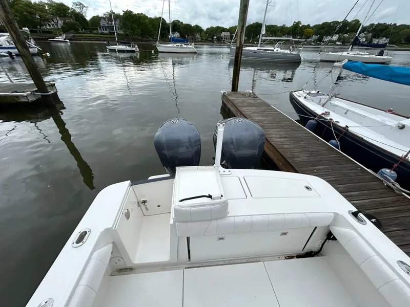 Slide: The Image of 2014 Regulator 34 boat docked with twin engines, surrounded by calm waters and sailboats. - 4