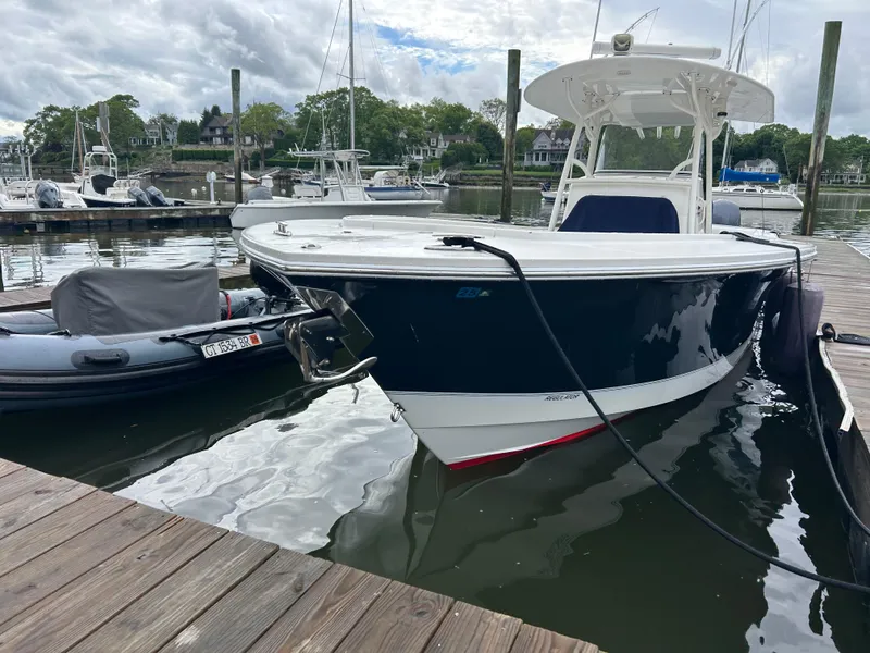 Slide: The Image of 2014 Regulator 34 boat docked in a marina, surrounded by calm water and other vessels. - 5