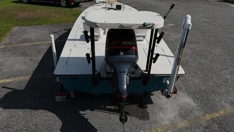 Slide: The Image of 1999 Maverick 21 Master Angler boat with outboard motor, parked on asphalt. - 8