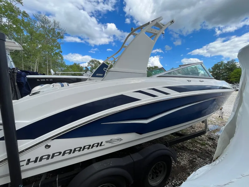 Slide: The Image of 2018 Chaparral Vortex 243 boat with sleek design, parked outdoors under a blue sky. - 10