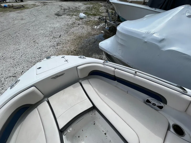 Slide: The Image of 2018 Chaparral Vortex 243 boat interior with white seating and blue accents. - 12