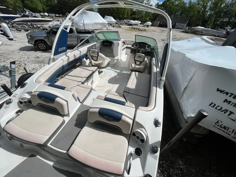 Slide: The Image of 2018 Chaparral Vortex 243 boat with spacious seating and modern design in a marina setting. - 5