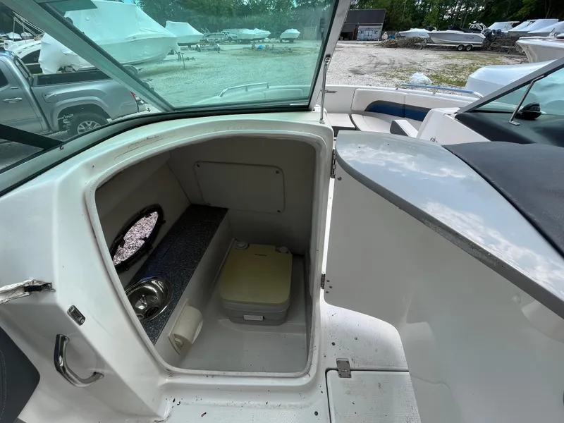 Slide: The Image of 2018 Chaparral Vortex 243 boat interior with storage compartment and portable toilet. - 9